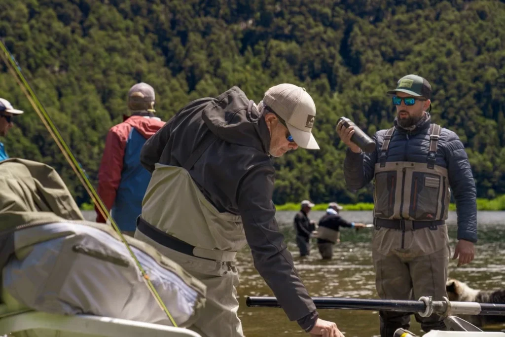 Des pêcheurs échangent au bord de l’eau pendant une sortie, d’autres pêchent en arrière-plan